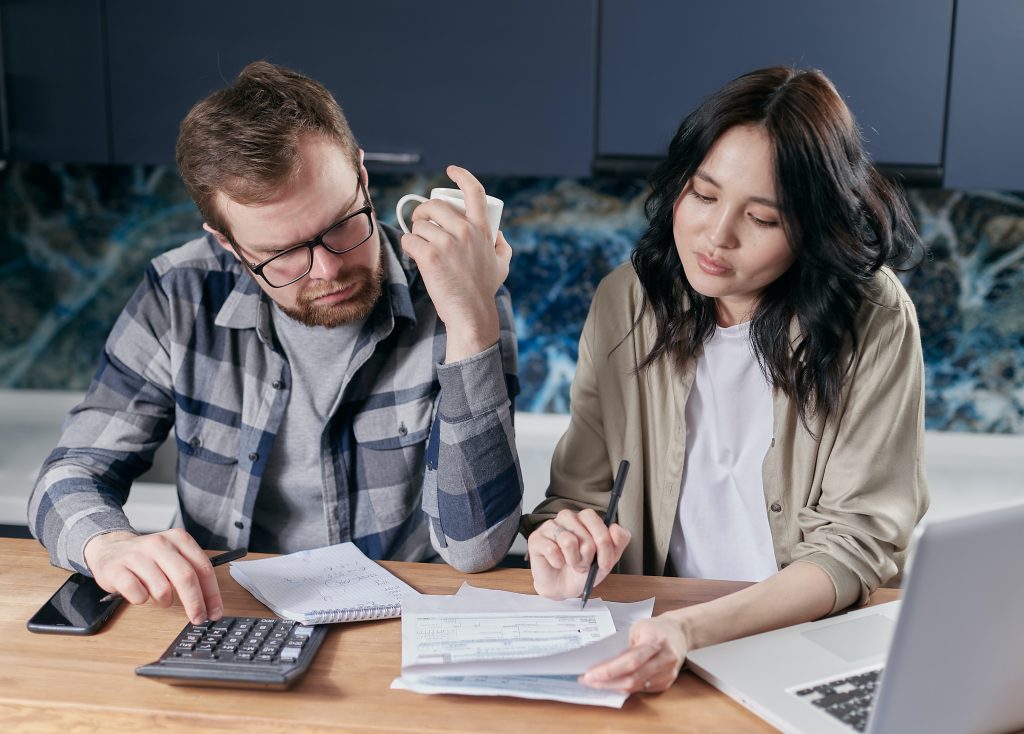 Couple reviewing their finances and using calculator