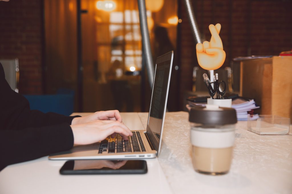 Hands typing on a laptop typing business ideas